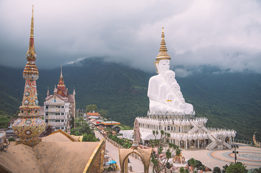 White big buddha aerial view with mountain background at Wat Prathat Phasornkaew, Khao Kho, Phetchabun, Thailand