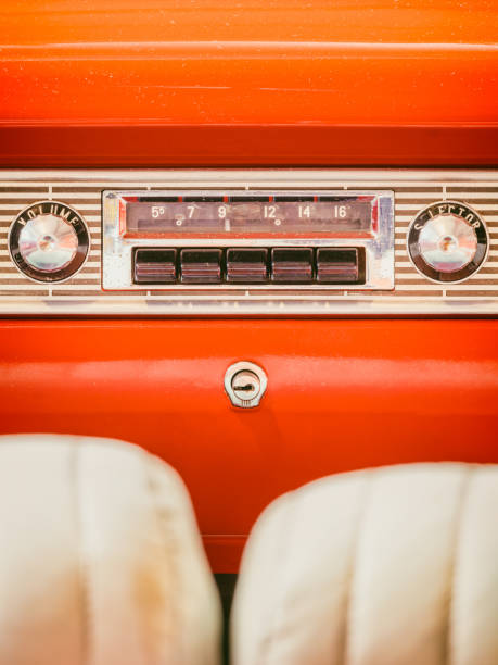 Old car radio inside an orange classic American car with chrome dashboard