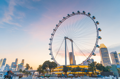 Beautiful view of downtown with giant Ferris wheel by Marina Bay in Singapore. Amazing cityscape. Singapore is a popular tourist destination of Asia.
