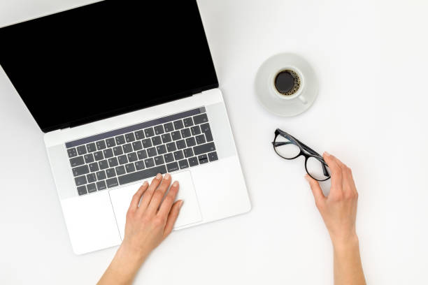istock Home office workspace mockup. Laptop with blank screen, hands and accessories on white background. Flat lay. Top view 1281282874