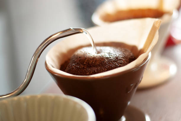 Hand drip coffee , Barista pouring water on coffee ground with filter