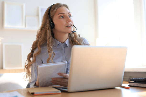 istock Freelance operator talking with headsets and consulting clients from home office. 1281288934
