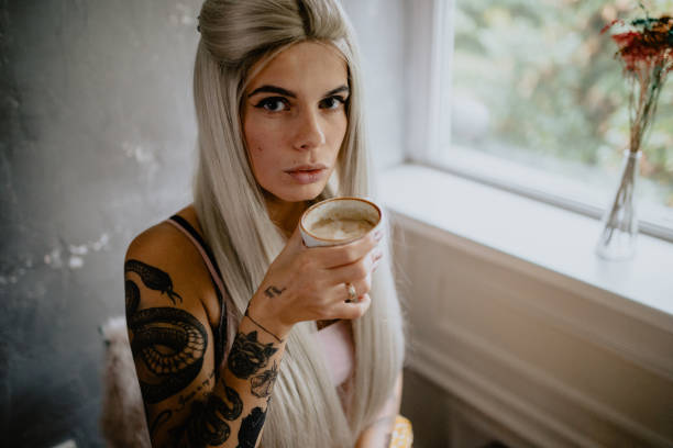 istock Beautiful tattooed woman drinking espresso coffee 1281290230