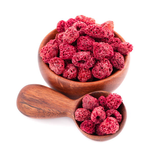 istock Dried raspberry isolated on white background. Dehydrated raspberry in wooden bowl and spoon. 1281290837