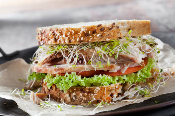 sandwich di tacchino arrosto con germogli di lattuga, pomodoro e pisello su pane integrale - portion turkey sandwich close up foto e immagini stock