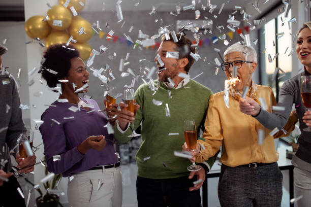 Celebrating business achievements in the office! Happy entrepreneurs having fun and celebrating their business success on a party in the office. office parties stock pictures, royalty-free photos & images