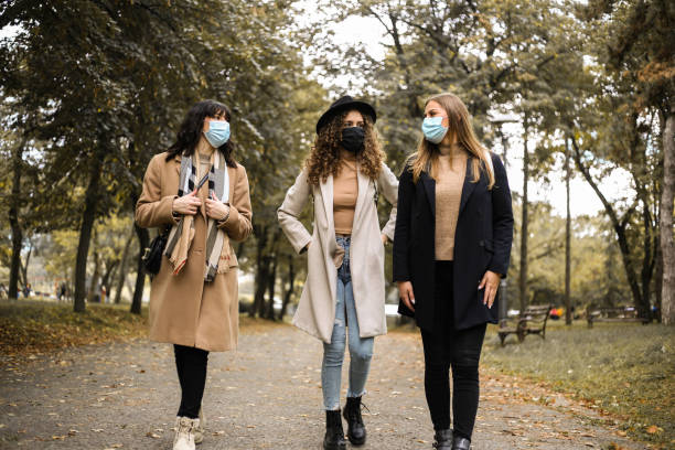 istock Females wearing protective face masks during Autumn walk in park 1281294963