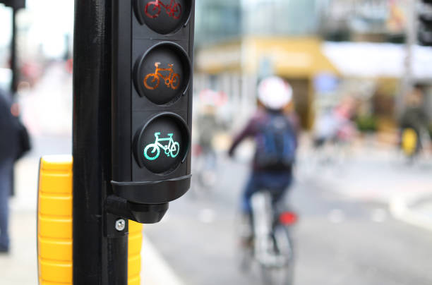 un ciclista che passa attraverso un semaforo verde a londra - bicycle london england cycling safety foto e immagini stock