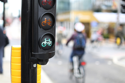 London, England - April 8, 2016: A traffic light for cyclists and a cyclist in the background shot with narrow depth of focus