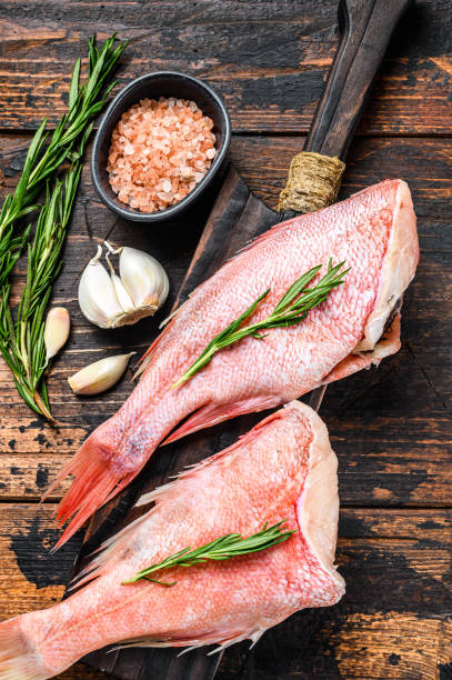 istock Whole raw fresh red perch or seabass fish.  Dark wooden background. Top view 1281297369