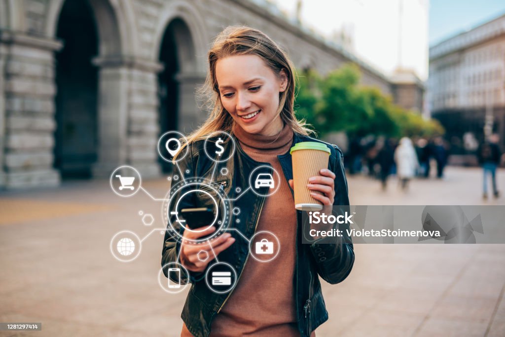Artificial intelligence and communication network concept. Beautiful young woman using a smartphone with various icons of smart technology. Technology Stock Photo