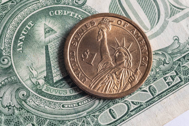 istock One dollar coin on the background of one dollar bill 1281300329