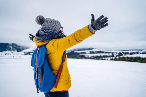 istock Woman with open arms on snowy mountain 1281300401