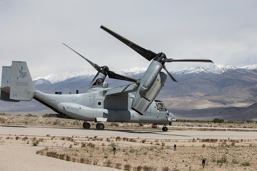Bishop Airport (KBIH),Bishop California, USA, May 8, 2014.   United States Marine Corps Osprey MV-22 Aircraft from Marine Squadrons, VMM-161 and VMM-162 perform high altitude landing and launching training.\n\nBishop Airport, (KBIH)  was built in 1928 and expanded and operated by the Army Air Corps during WWII.  During the war it was used as a military flight training base and boasted a chow hall and barracks for pilots during training.  Because of its strategic location east of the 12,000 foot tall Sierra Nevada Mountain range Bishop would be used as a Fall Back Base in the event the Japanese military attacked the California coast. \n  \nToday the airport has multiple modern navigational aids and is used by civilian aircraft and all branches of the US military for training and fuel stops.  Bishop has a military fuel contract which allows any military aircraft to purchase fuel.  Because of its close proximity to the Marine Corps High Altitude Training Facility at Pickle Meadows, Bishop is a vital fuel stop.  Aircraft leave their bases on the California coast fully laden with troops and after depositing them at Pickle Meadows stop at Bishop for fuel.  \n\n Aircraft perform differently at higher altitudes than at sea level.  Performance is affected by altitude, weight and available power.  Fuel, cargo and passenger loads must be calculated based on altitude, weight and aircraft power.  On a 100 degree day at Bishop's 4,200 foot elevation an aircraft will perform as though it was launching from an airport located 8,000 feet above sea level.  This phenomena is known as Density Altitude.  During workups for deployment to Afghanistan military air units practice in and around the Bishop area because of the high elevation of the airport, sparse population and similarity of terrain.  Copyright Kenneth Babione