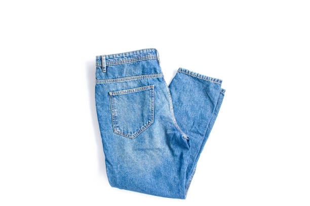 gefaltete blaue jeans auf weißem hintergrund. moderne freizeitkleidung. flachliegen, kopierraum - pants stock-fotos und bilder