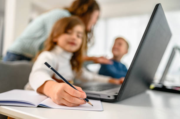 istock Mother helping her kids with online schooling 1281304586