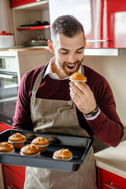 istock Young man wearing apron and preparing muffins in his kitchen 1281307283
