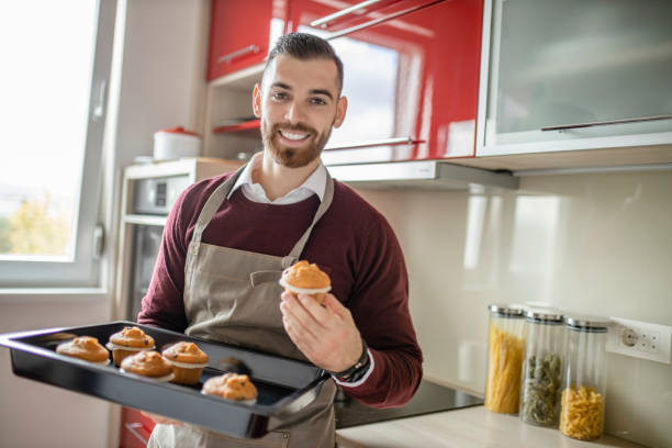 istock Young man wearing apron and preparing muffins in his kitchen 1281307747