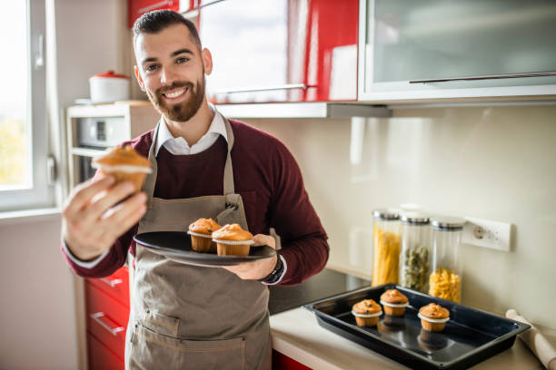 istock Young man wearing apron and preparing muffins in his kitchen 1281308578