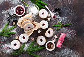 Traditional Christmas Linzer cookies with raspberry jam on dark background.