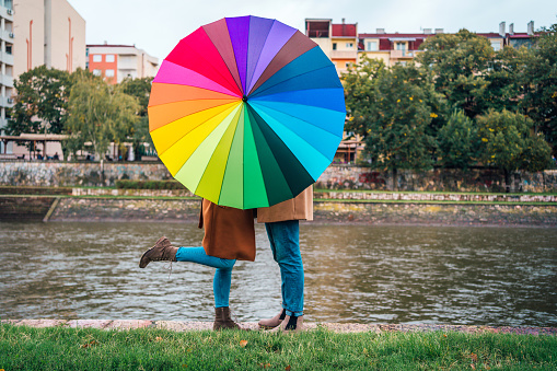 Couple kissing behind an umbrella near the river