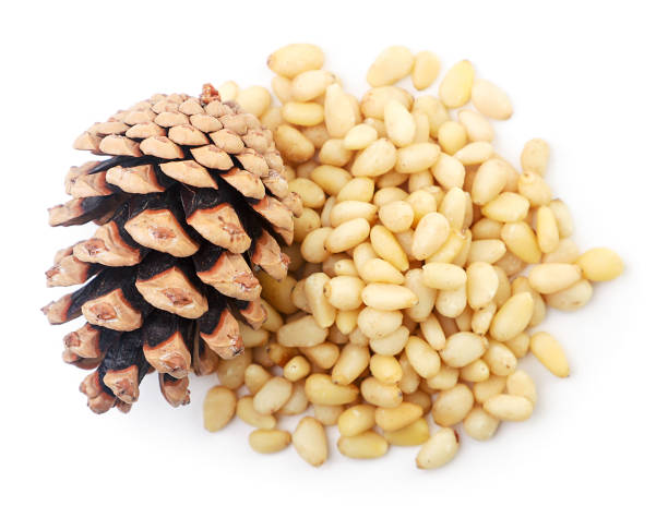 istock Heap of pine nuts and pine cone on white background, isolated. The view from top 1281312812