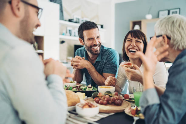 partager la nourriture et les bons rires - dîner photos et images de collection