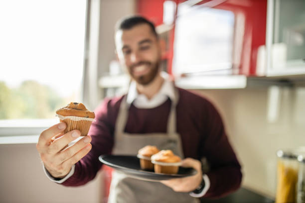 istock Young man wearing apron and preparing muffins in his kitchen 1281315635