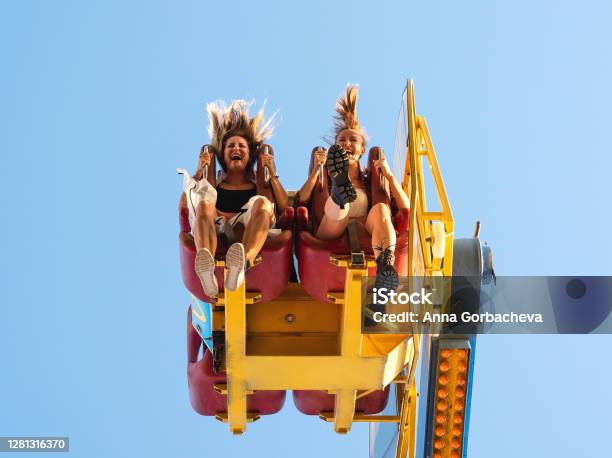 Two Women At Amusement Park Stock Photo - Download Image Now - Amusement Park, Amusement Park Ride, Carousel