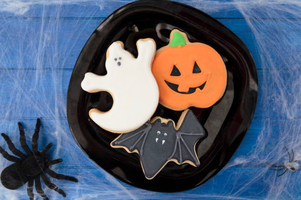 istock Top view of halloween biscuits on blue wooden table decorated with spider web and spiders 1281319183