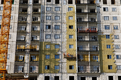 Moscow, Russia - September 13, 2020 : Construction of a residential apartment building covering insulation process.