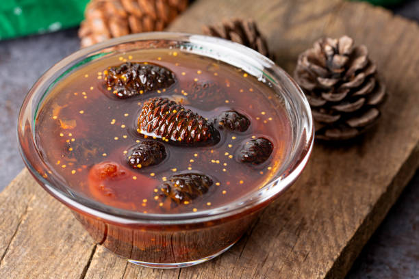 young pine cones jam in glass bowl on wooden board. delicious jam with the little pine cones. - maple tree imagens e fotografias de stock