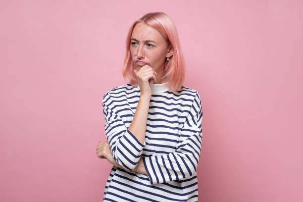 istock Confused young woman looking away, thinking and trying to make a decision 1281322399