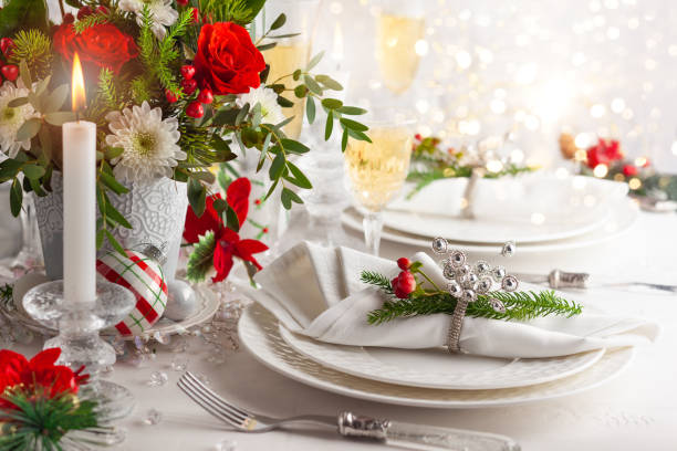 Christmas or New Year dinner concept. Festive table setting with winter flower arrangement on table decorated for holiday. Christmas or New Year dinner concept. rose christmas red white stock pictures, royalty-free photos & images