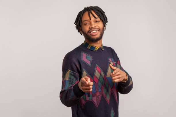 istock Hey you! Satisfied handsome guy with dreadlocks pointing fingers at camera and looking with toothy smile, flirting, admiring 1281323520