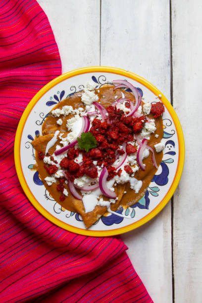 istock Mexican enfrijoladas with chorizo and cheese on white background 1281328163