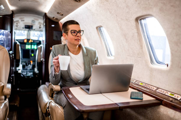 istock Business woman in a private jet airplane having a tea 1281329399