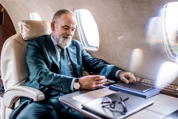 istock Male CEO using a phone on a flight in a private jet airplane 1281330619