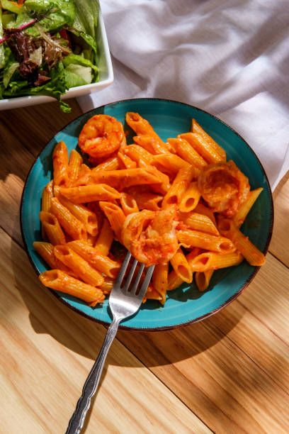 Shrimp Penne Alla Vodka Penne alla vodka with shrimp and side salad vodka sauce stock pictures, royalty-free photos & images