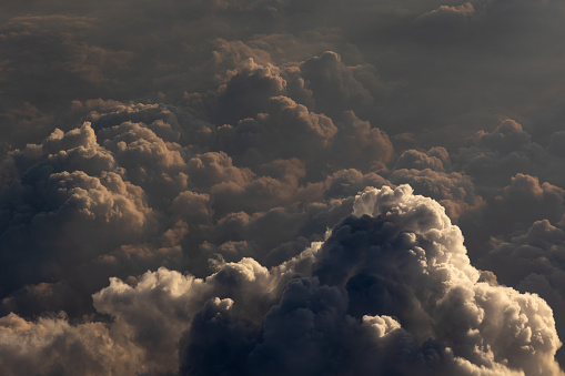 Flying above a layer of puffy cumulus clouds at sunset