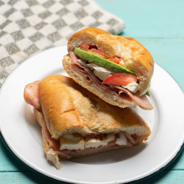 istock Mexican ham sandwich with avocado and cheese also called torta on turquoise background 1281334226