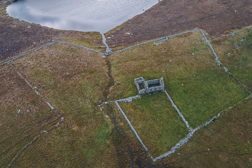 Aerial view of the abandoned croft, farm house next to small lake near Westing on the island of Unst in Shetland, Scotland.