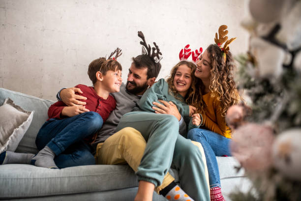 istock Family hugging each other on sofa on New Year's morning. 1281345518