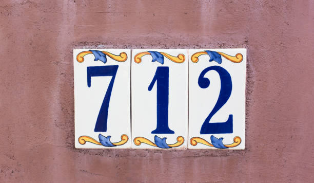 Colorful Ceramic Number 712 Street Address Tile Ceramic Number 712 Street Address; Colorful Mexican floral tiles on adobe wall. Shot in Santa Fe, NM. ceramic tile house numbers stock pictures, royalty-free photos & images