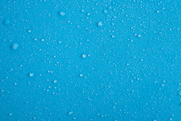 istock Full frame backdrop of water droplets splatter on blue background 1281349018