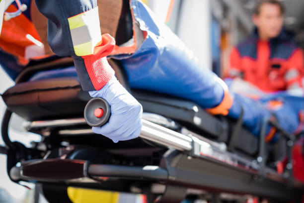 Selective focus of paramedic in latex glove holding stretcher with patient outdoors Selective focus of paramedic in latex glove holding stretcher with patient outdoors stretcher stock pictures, royalty-free photos & images