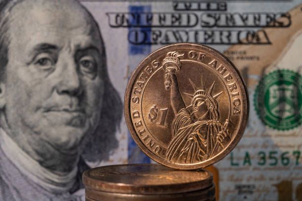 istock Metal dollar and 100 dollar bill 1281354343