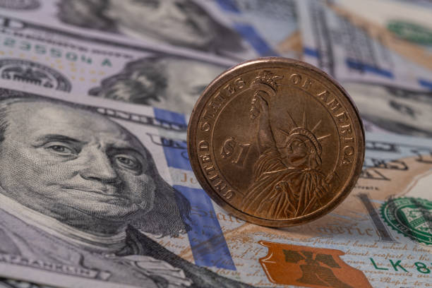 istock Metal dollar and 100 dollar bill 1281354352