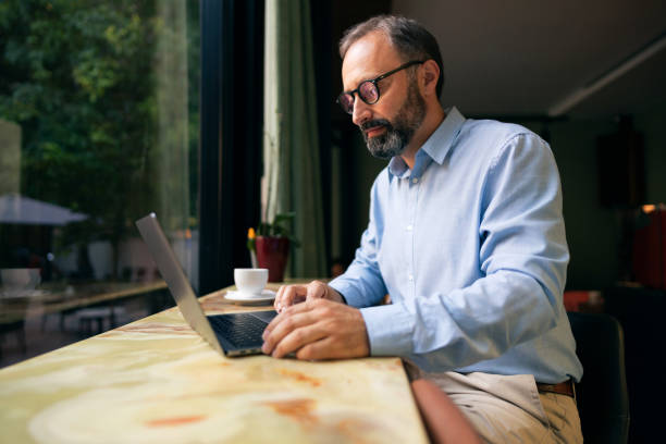 istock Businessman sitting at the restaurant and using a laptop 1281355682