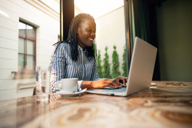 istock Young African ethnicity freelancer working on her laptop at the coffee place 1281355713